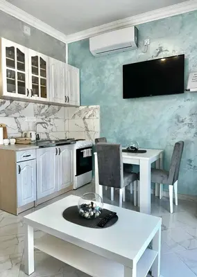 a kitchen with white tables and a tv on the wall at Albomi in Kotor