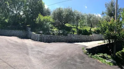 a stone retaining wall next to a road at Albomi in Kotor