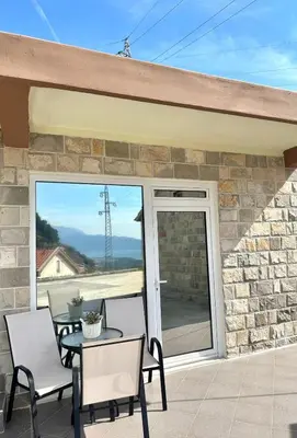 a patio with a table and chairs and a glass door at Albomi in Kotor