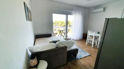 a bedroom with a couch and a bed with a balcony at Olav Holiday Apartments Bar in Bar