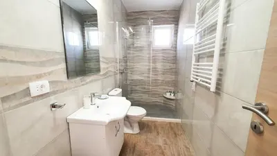 a bathroom with a toilet and a sink and a shower at Olav Holiday Apartments Bar in Bar