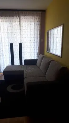 a living room with a couch and two windows at BH Rialto in Sveti Stefan