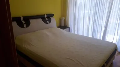 a bedroom with a bed and a window with curtains at BH Rialto in Sveti Stefan