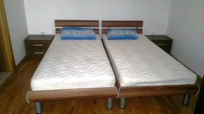 two twin beds in a room with wooden floors at BH Rialto in Sveti Stefan