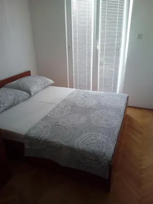 a bedroom with a bed and a large window at Apartman Milica in Budva