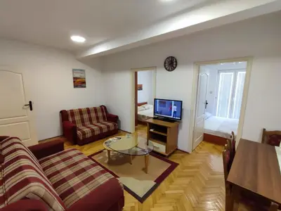 a living room with a couch and a tv at Apartman Milica in Budva
