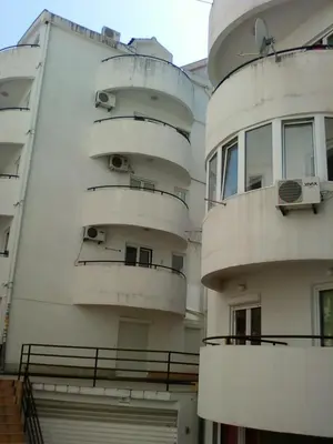a white building with balconies on the side of it at Apartman Milica in Budva
