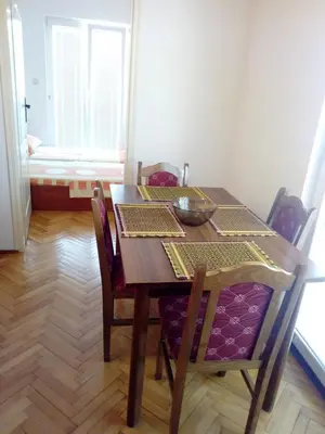 a dining room table with chairs and a bowl on it at Apartman Milica in Budva