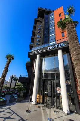 a hotel with palm trees in front of it at Hotel Del Medio in Sutomore