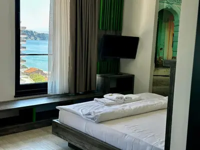 a bedroom with a bed with a view of the ocean at Hotel Del Medio in Sutomore