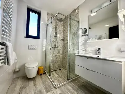 a bathroom with a shower and a toilet and a sink at Hotel Del Medio in Sutomore