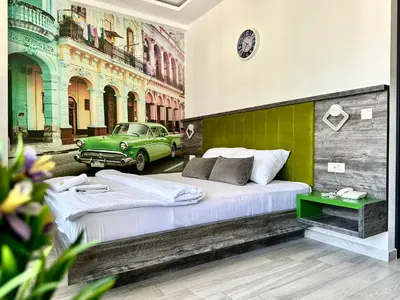 a bedroom with two beds and a green car at Hotel Del Medio in Sutomore