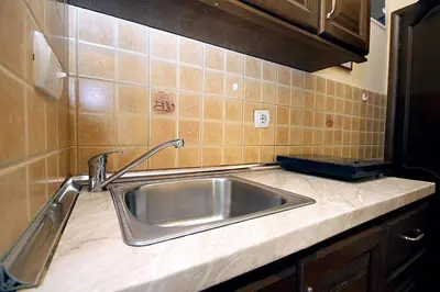 a kitchen counter with a stainless steel sink at Villa Jupok in Bar