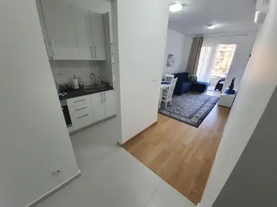 a kitchen and a living room with white cabinets at AS Apartments Budva in Budva