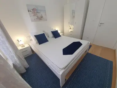 a bedroom with a white bed with blue pillows at AS Apartments Budva in Budva