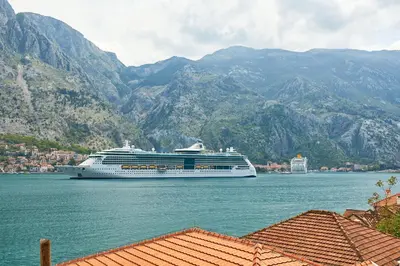 a cruise ship in the water with mountains in the background at Blanka Sea View Apartments in Kotor