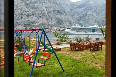 a playground with a cruise ship in the background at Blanka Sea View Apartments in Kotor
