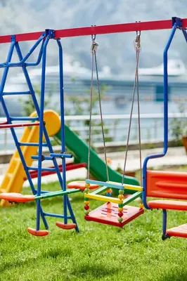 a row of colorful swings on a playground at Blanka Sea View Apartments in Kotor