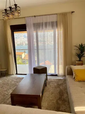 a living room with a coffee table in front of a window at Blanka Sea View Apartments in Kotor