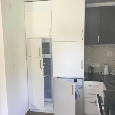a kitchen with white cabinets and a refrigerator at Vila Jovana in Sutomore