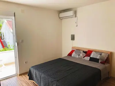 a bedroom with a bed and a window at Vila Jovana in Sutomore