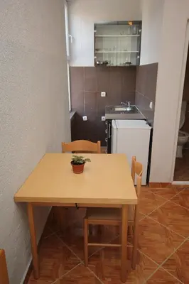 a wooden table with a potted plant on it in a kitchen at Apartments DEA in Bar