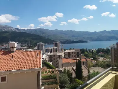 a view of a city with a lake and mountains at Ksenija apartment in Budva