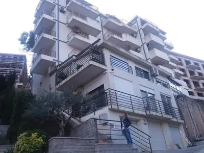 a person standing on a railing in front of a building at Ksenija apartment in Budva