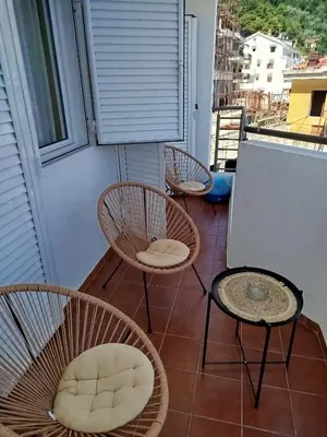 three chairs and a table on a balcony at Ksenija apartment in Budva