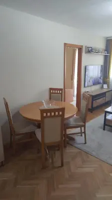 a dining room with a wooden table and chairs at Ksenija apartment in Budva