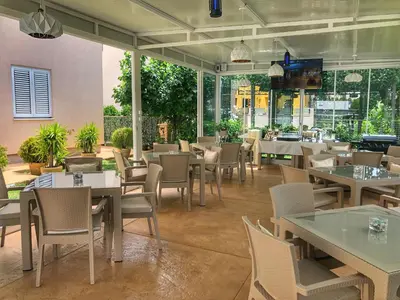 a restaurant with tables and chairs and windows at Villa Kovacevic in Bar