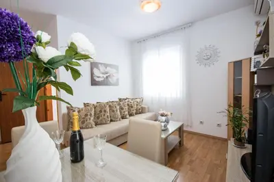 a living room with a couch and a table with flowers at Villa Kovacevic in Bar