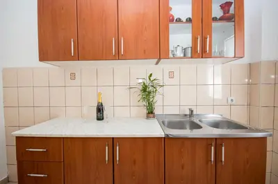 a kitchen with wooden cabinets and a sink at Villa Kovacevic in Bar
