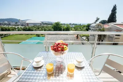 a table with a bowl of fruit on a balcony at Villa Kovacevic in Bar
