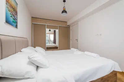 two beds in a bedroom with white sheets at Blue Marlin Apartments in Budva
