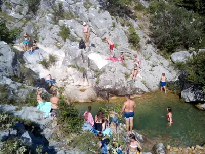 a group of people swimming in a pool of water at Rustic Stone House in Bar