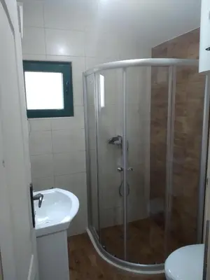 a bathroom with a shower and a sink at Rustic Stone House in Bar