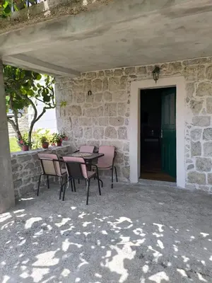 a patio with a table and chairs in a stone building at Rustic Stone House in Bar