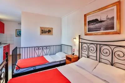 a bedroom with two beds and a kitchen at Apartmani Luka - Vila Brzulovic in Rafailovici