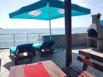 a patio with a table and chairs and an umbrella at Summer Holiday House MM in Ulcinj