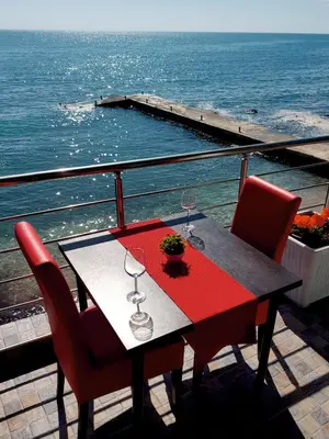 a table and chairs on a balcony with the ocean at Summer Holiday House MM in Ulcinj
