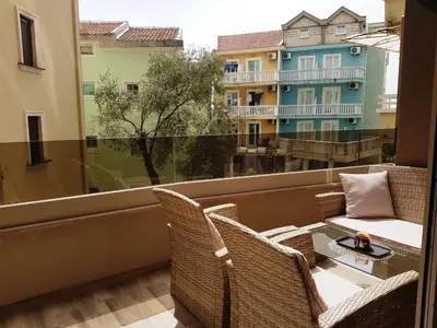 a balcony with a table and chairs and a window at Lux Apartment Teodora Rafailovici in Rafailovici