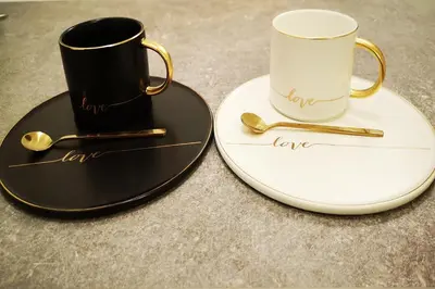 two coffee cups and plates with gold spoons at Lux Apartment Teodora Rafailovici in Rafailovici