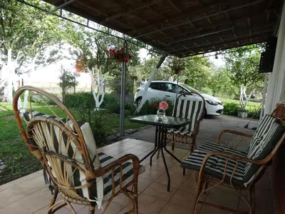 a patio with chairs and a table and a car at Apartman Zorana in Bar