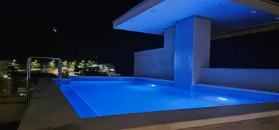 a swimming pool on a building at night at Lunde Sea View Apartment in Rafailovici
