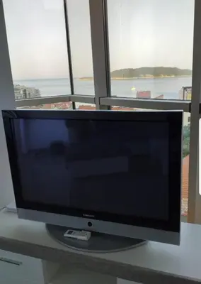 a computer monitor sitting on a desk in front of a window at Lunde Sea View Apartment in Rafailovici