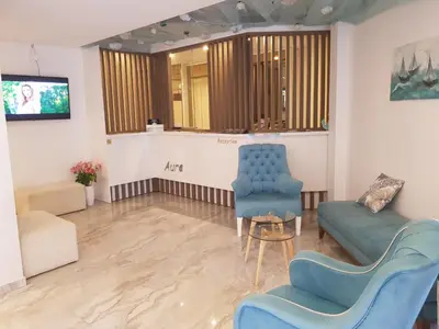 a waiting room with blue chairs and a table at Lunde Sea View Apartment in Rafailovici