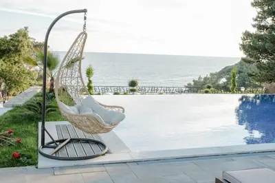a swinging chair next to a swimming pool at Pino Boutique Hotel in Ulcinj