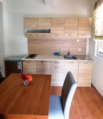 a kitchen with a wooden table and a wooden counter top at Residence Bella in Budva