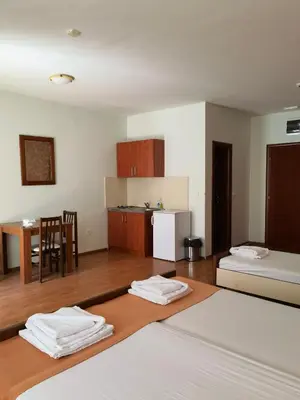 a room with two beds and a kitchen with a table at Residence Bella in Budva